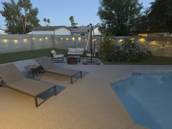 a view of a patio with table and chairs with wooden floor and fence