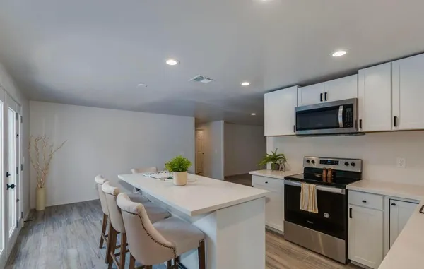 a kitchen with a sink a microwave and cabinets