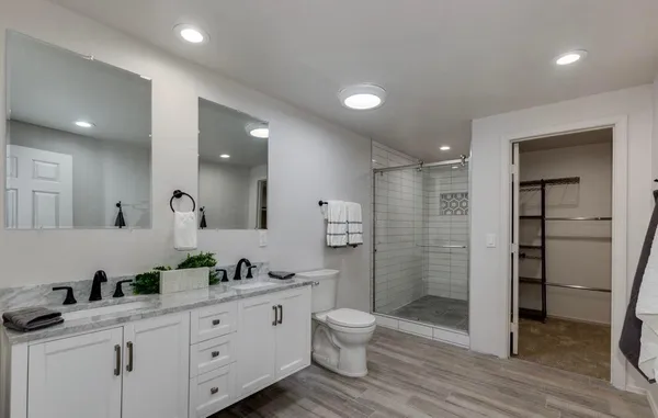 a bathroom with a double vanity sink toilet and shower