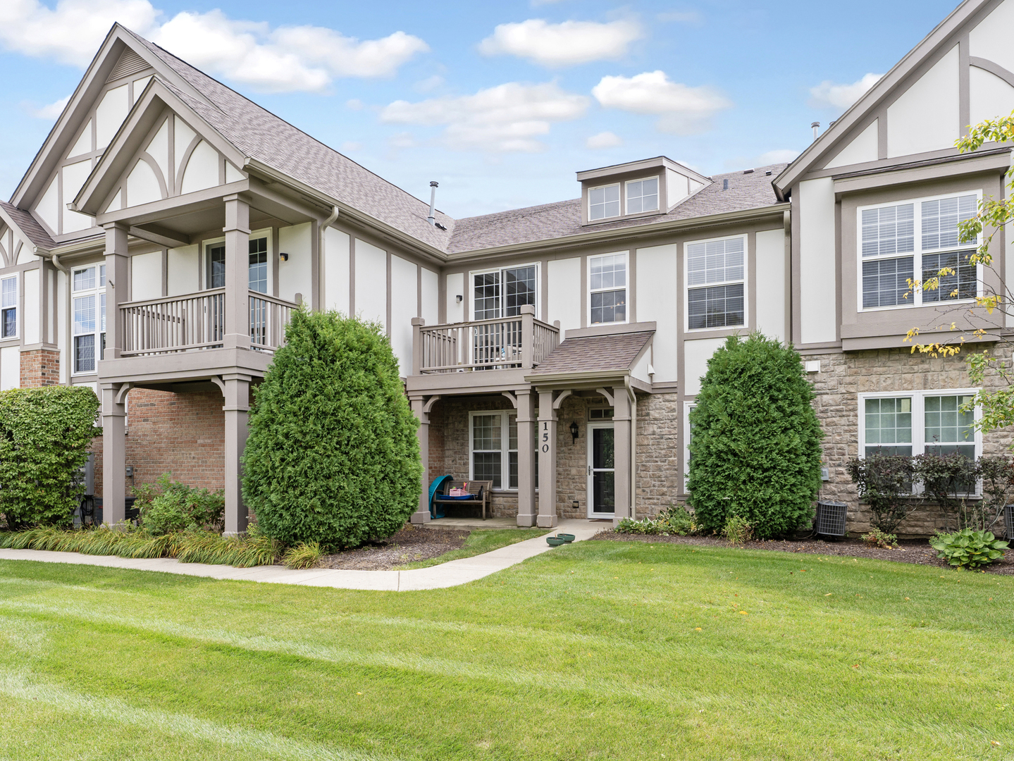 880 June Terrace, Unit 270 Lake Zurich, IL 60047 - Photo 2 of 26 front view of a brick house with a yard
