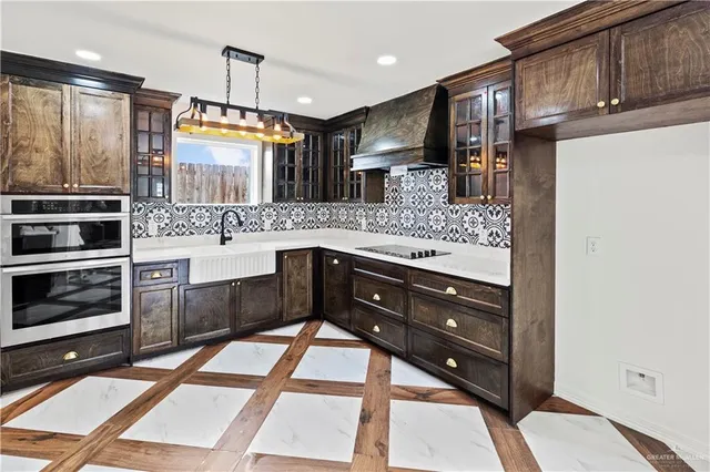 a kitchen with stainless steel appliances kitchen island granite countertop wooden cabinets and a stove