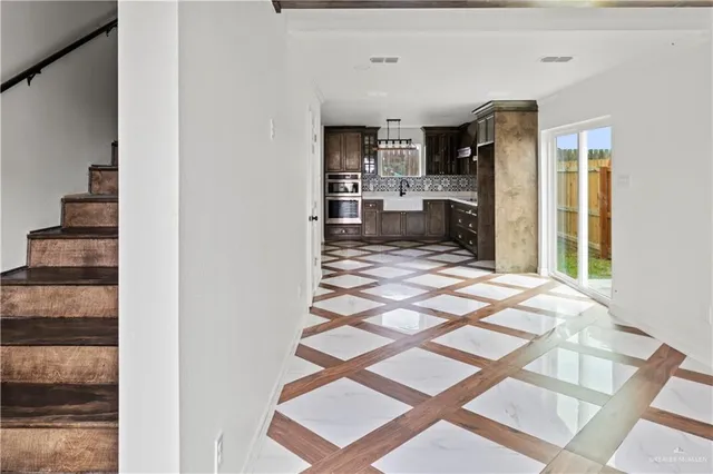 a kitchen with stainless steel appliances kitchen island granite countertop a refrigerator and a sink