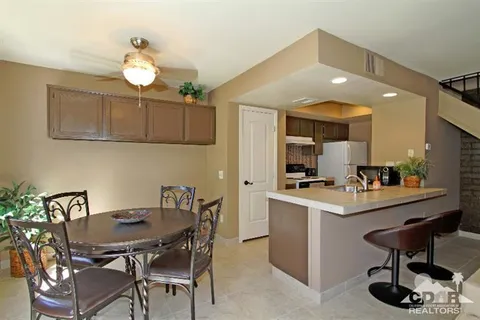 a kitchen with a dining table chairs and white cabinets