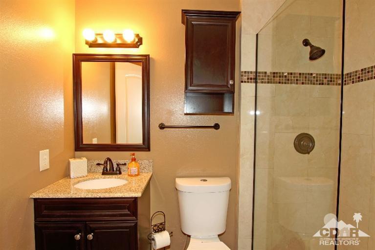 72664 Eagle Road, Unit 3 Palm Desert, CA 92260 - Photo 10 of 16 a bathroom with a granite countertop sink toilet and shower