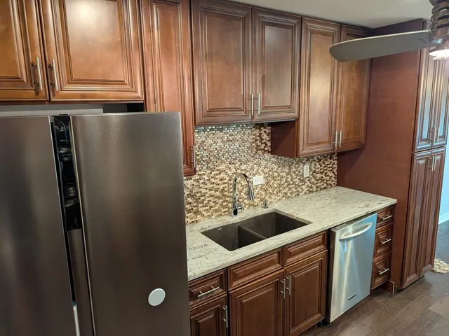 a kitchen with stainless steel appliances granite countertop a refrigerator and a sink