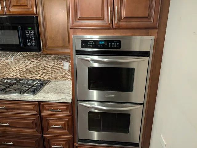 a stove top oven sitting inside of a kitchen
