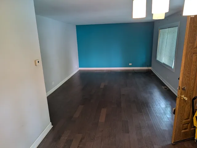 a view of a room with wooden floor and windows
