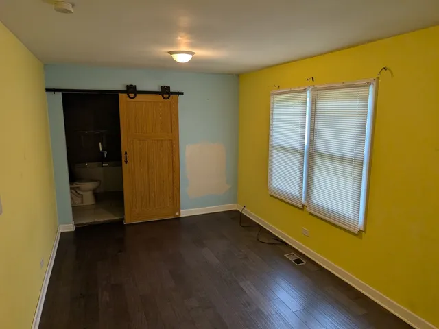 an empty room with wooden floor and closet