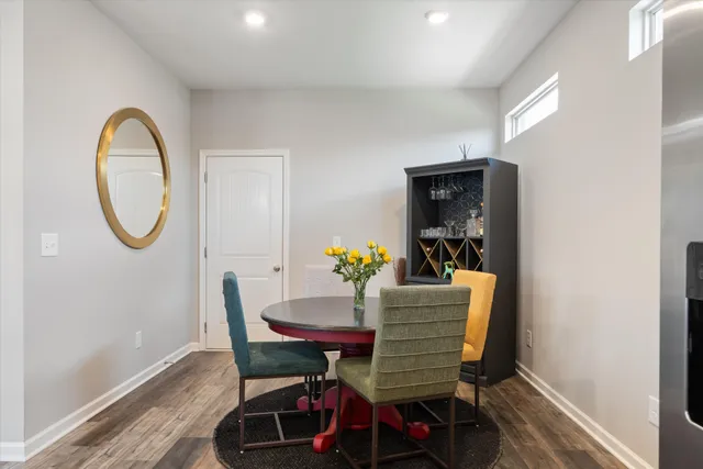 a dining room with furniture a mirror and a wooden floor