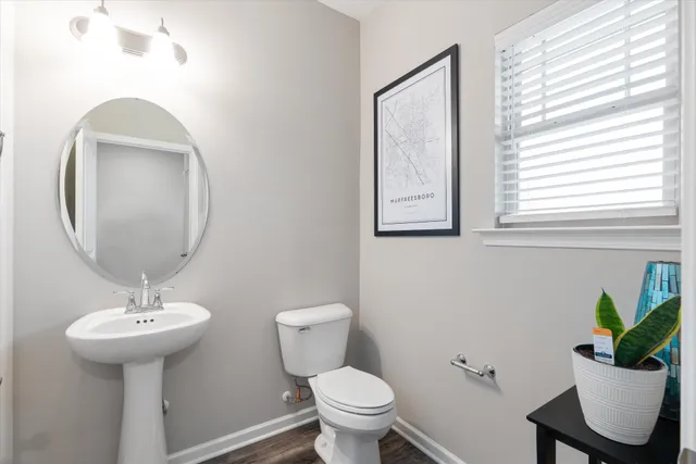 a bathroom with a toilet sink and mirror