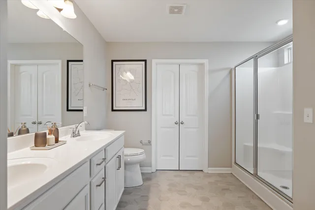 a spacious bathroom with a double vanity sink a mirror and a shower