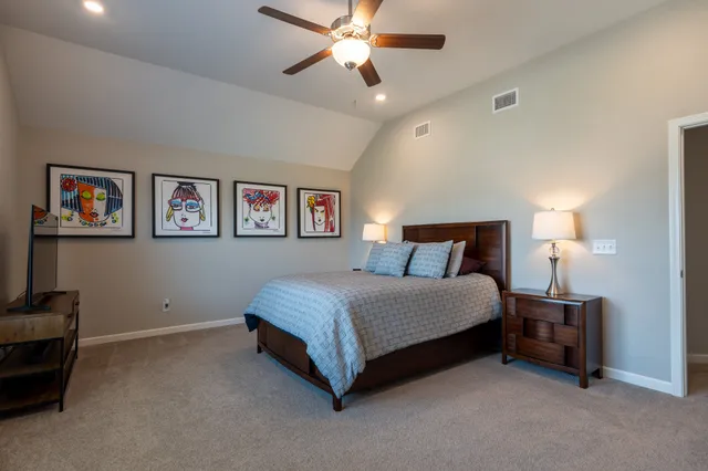 a spacious bedroom with a bed and a chandelier