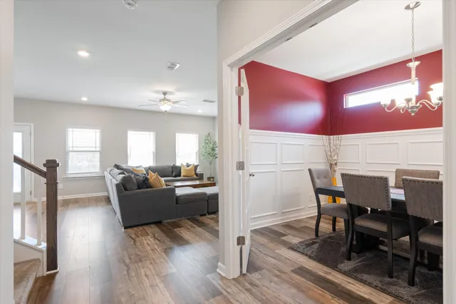 a view of a dining room with furniture a chandelier and wooden floor