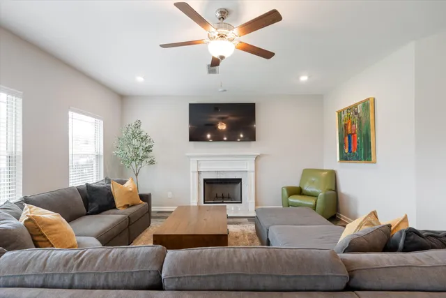 a living room with furniture a fireplace and a flat screen tv