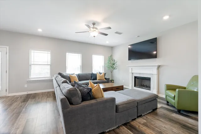 a living room with furniture a flat screen tv and a fireplace