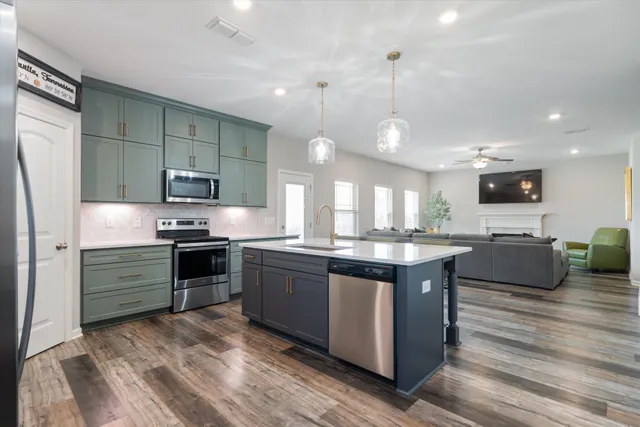 a open kitchen with stainless steel appliances granite countertop a stove and a refrigerator
