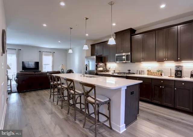 a kitchen with stainless steel appliances kitchen island granite countertop a stove a sink a microwave a center island and a cabinets