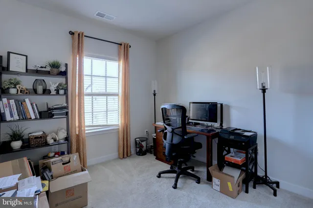 a view of a workspace with furniture and a window