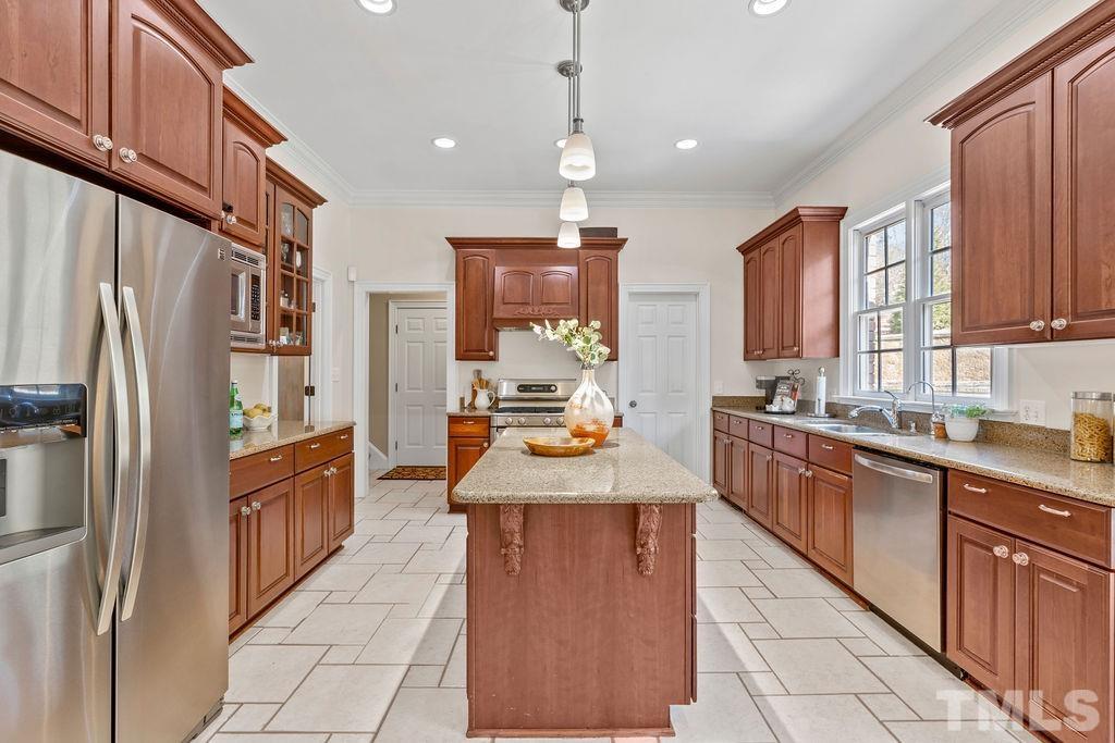 5844 Applegarth Lane Raleigh, NC 27614 - Photo 17 of 70 a large kitchen with stainless steel appliances granite countertop a refrigerator a sink dishwasher a stove with wooden cabinets