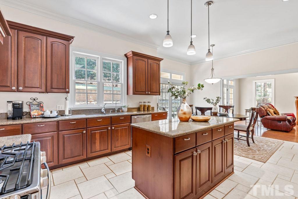 5844 Applegarth Lane Raleigh, NC 27614 - Photo 20 of 70 a kitchen with stainless steel appliances a sink stove and wooden cabinets