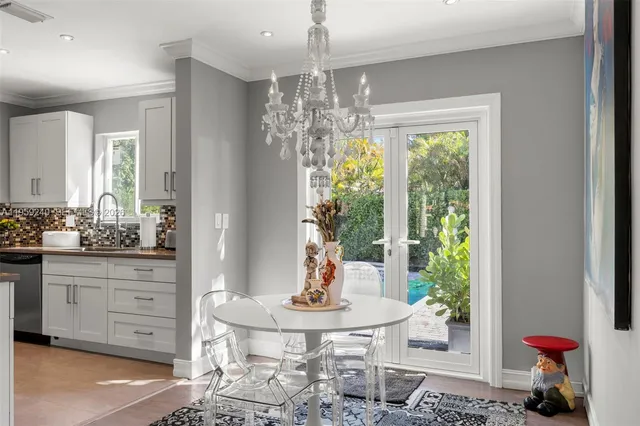 a dining room with furniture a chandelier and window