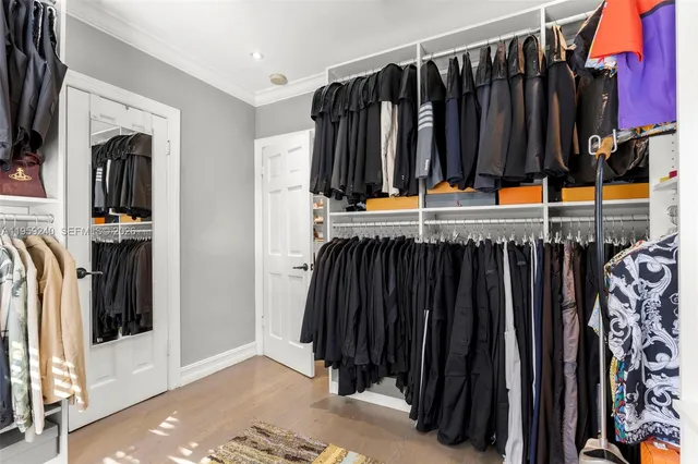 a view of walk in closet with clothes and shoes