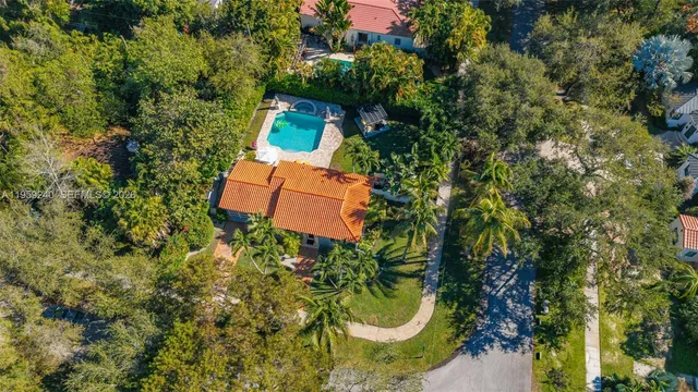 an aerial view of a house with swimming pool and garden