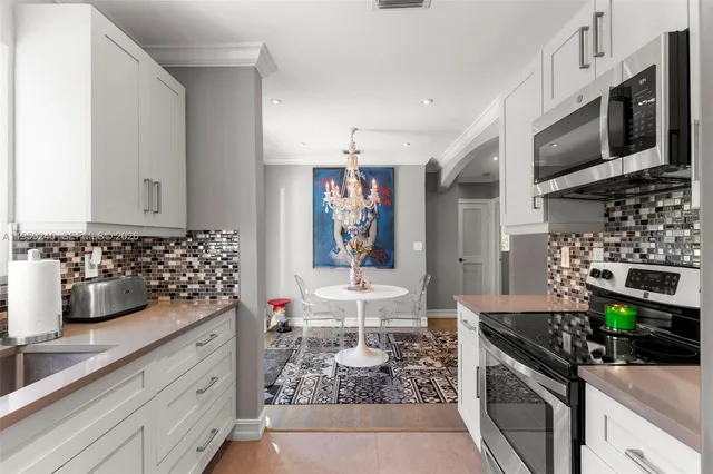 a kitchen with stainless steel appliances kitchen island granite countertop a stove and cabinets