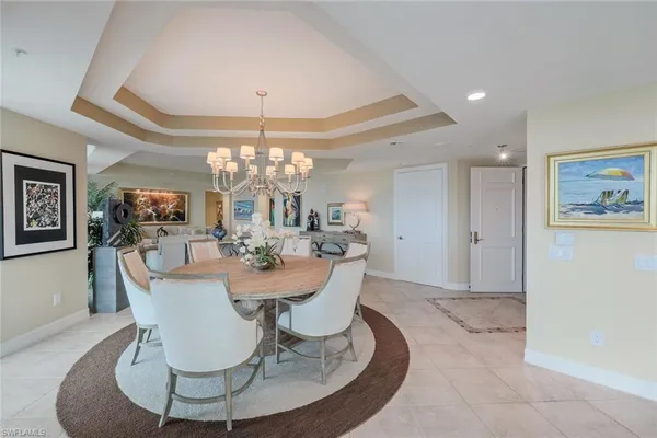 a view of a dining room with furniture a chandelier and wooden floor