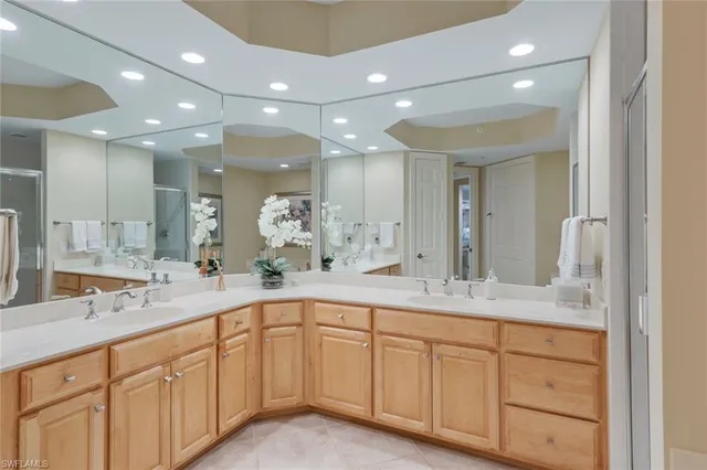 a spacious en suite bathroom with double sink and a mirror