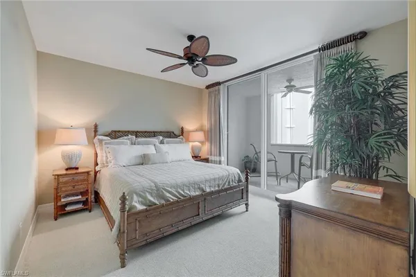 a bedroom with a bed a chandelier and a window