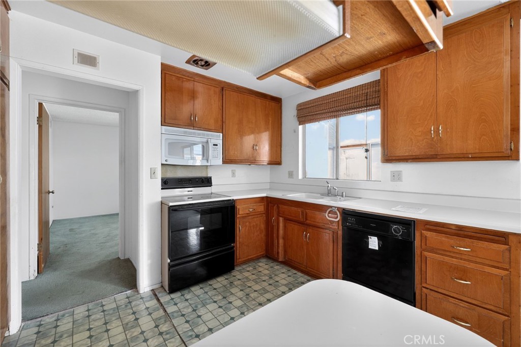 11675 Calvin Street Yucaipa, CA 92399 - Photo 18 of 30 a kitchen with granite countertop stainless steel appliances a stove sink and cabinets