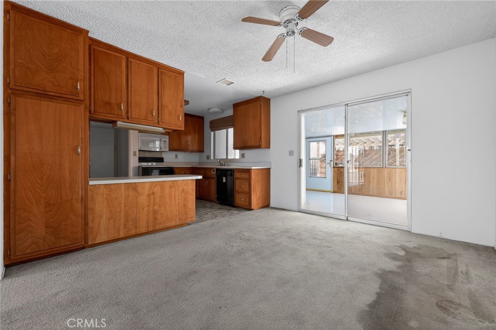 11675 Calvin Street Yucaipa, CA 92399 - Photo 21 of 30 a large kitchen with stainless steel appliances kitchen island granite countertop a refrigerator a stove top oven a sink and dishwasher