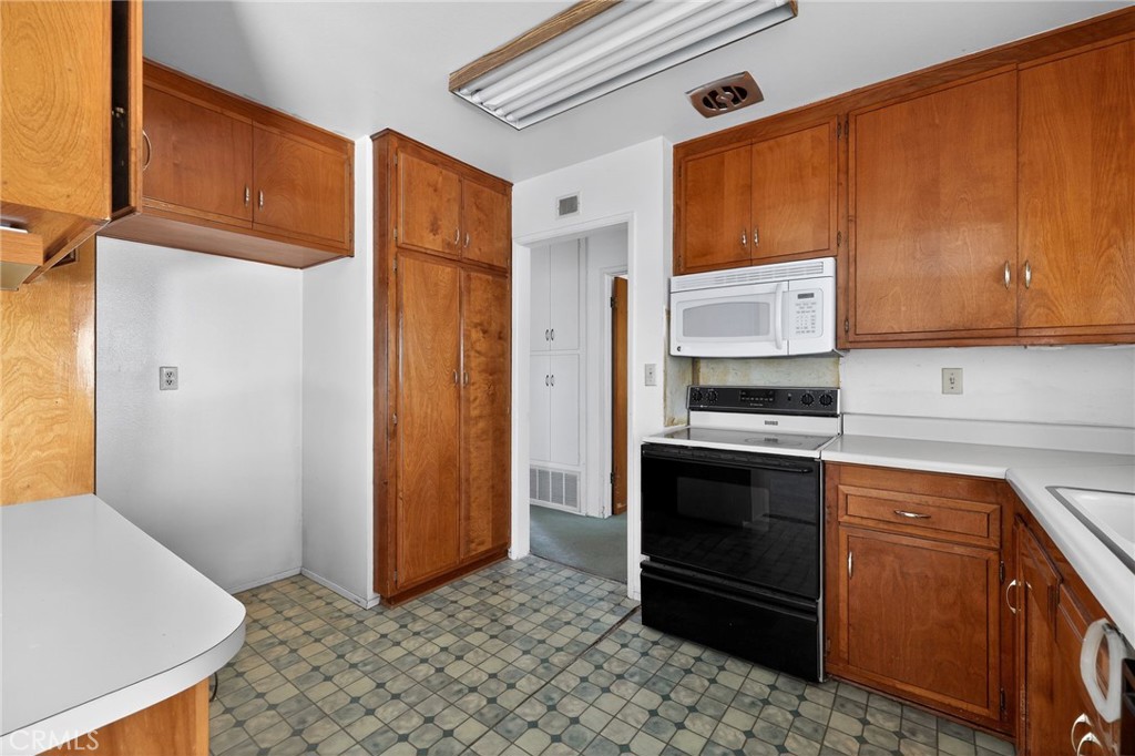11675 Calvin Street Yucaipa, CA 92399 - Photo 23 of 30 a kitchen with stainless steel appliances granite countertop a refrigerator and a stove top oven