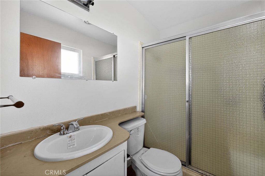 11675 Calvin Street Yucaipa, CA 92399 - Photo 28 of 30 a bathroom with a sink toilet a mirror and shower