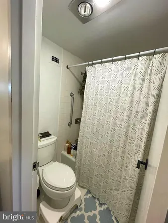 a white toilet sitting next to a shower curtain