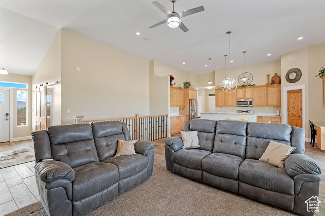 19502 South Olson Road Downey, ID 83234 - Photo 9 of 64 Living area featuring high vaulted ceiling, a ceiling fan, recessed lighting, a barn door, and a chandelier