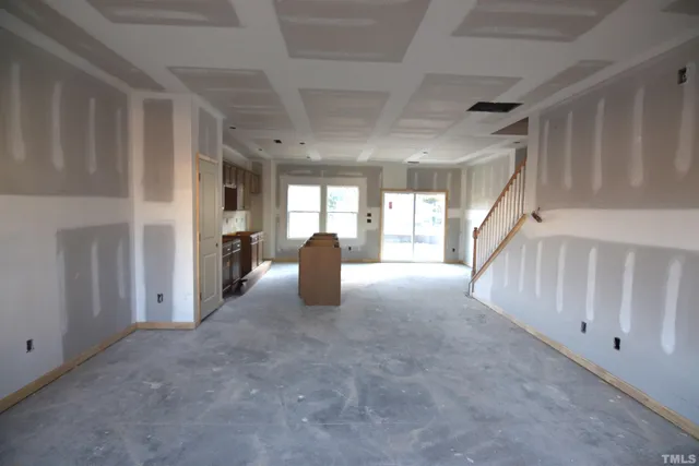 a kitchen with stainless steel appliances granite countertop a stove top oven a sink a dining table and chairs with wooden floor