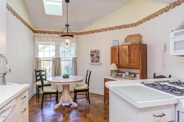 a dining room with a table chairs and a kitchen view