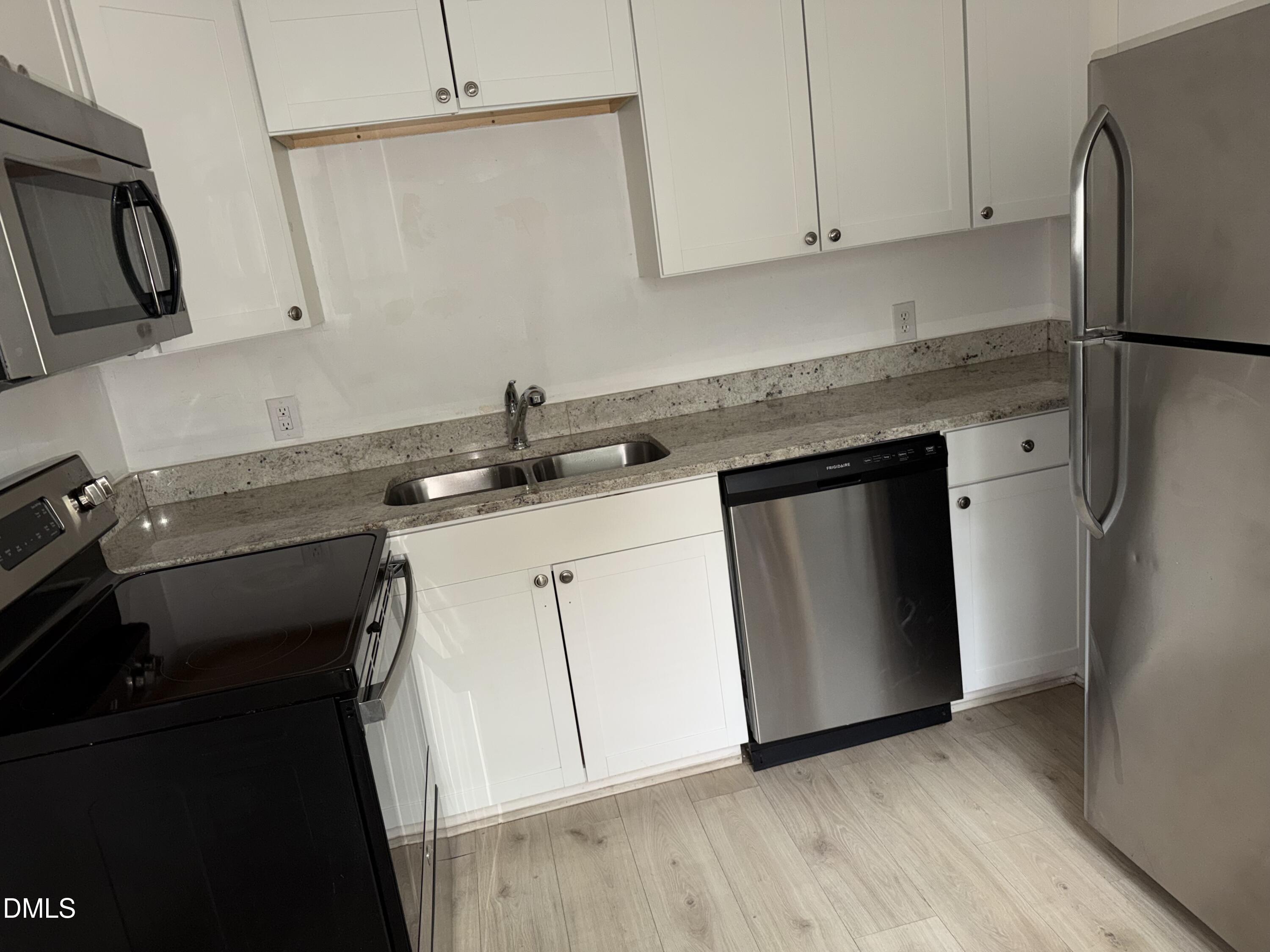 1107 Worth Street Durham, NC 27701 - Photo 15 of 17 a kitchen with a sink and a refrigerator