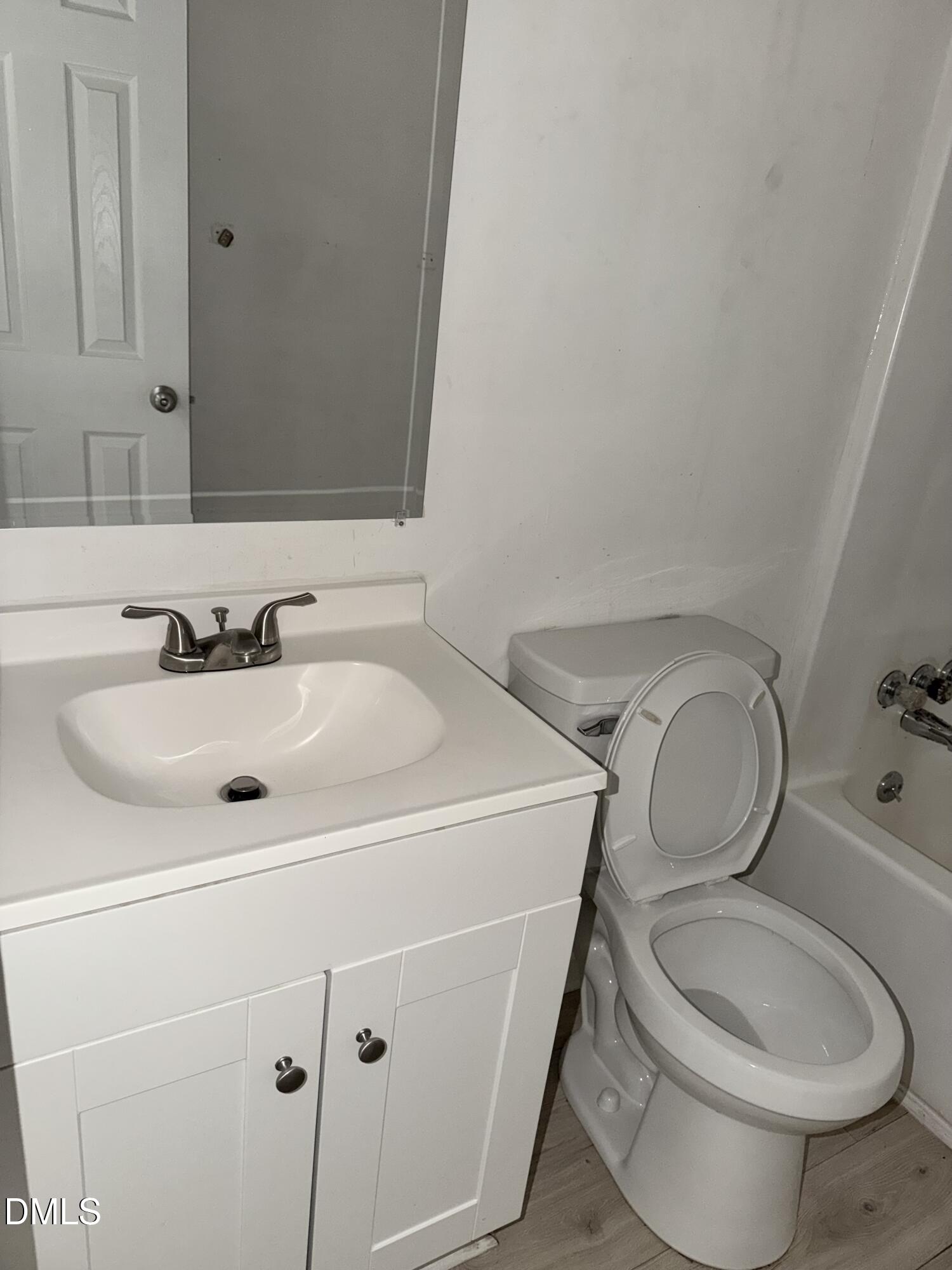 1107 Worth Street Durham, NC 27701 - Photo 3 of 17 a bathroom with a sink mirror vanity and toilet