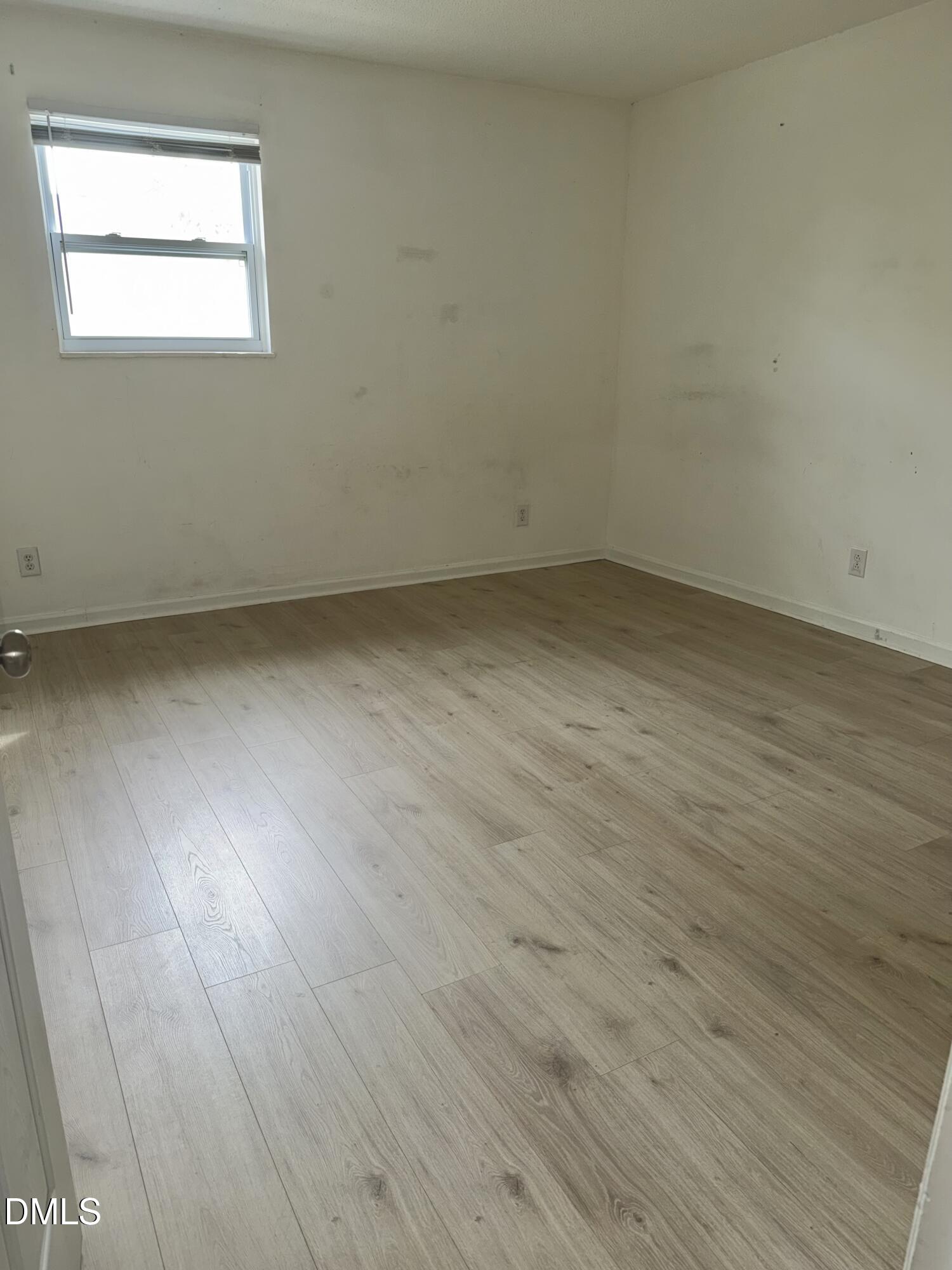 1107 Worth Street Durham, NC 27701 - Photo 4 of 17 an empty room with wooden floor and windows
