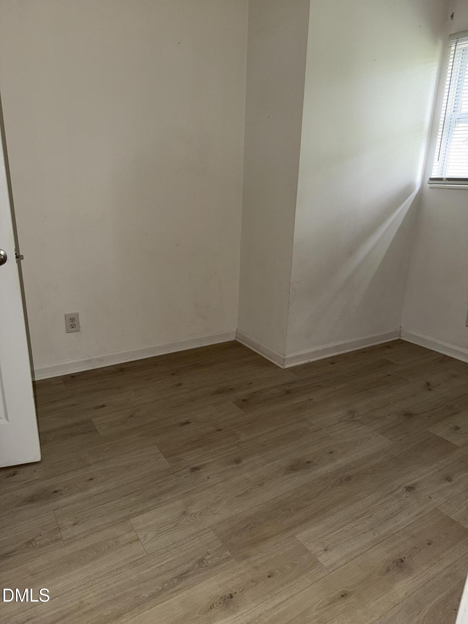 1107 Worth Street Durham, NC 27701 - Photo 6 of 17 an empty room with wooden floor and windows