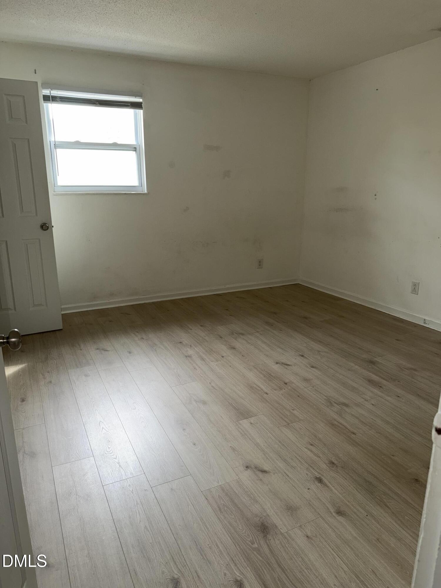 1107 Worth Street Durham, NC 27701 - Photo 8 of 17 an empty room with wooden floor and windows