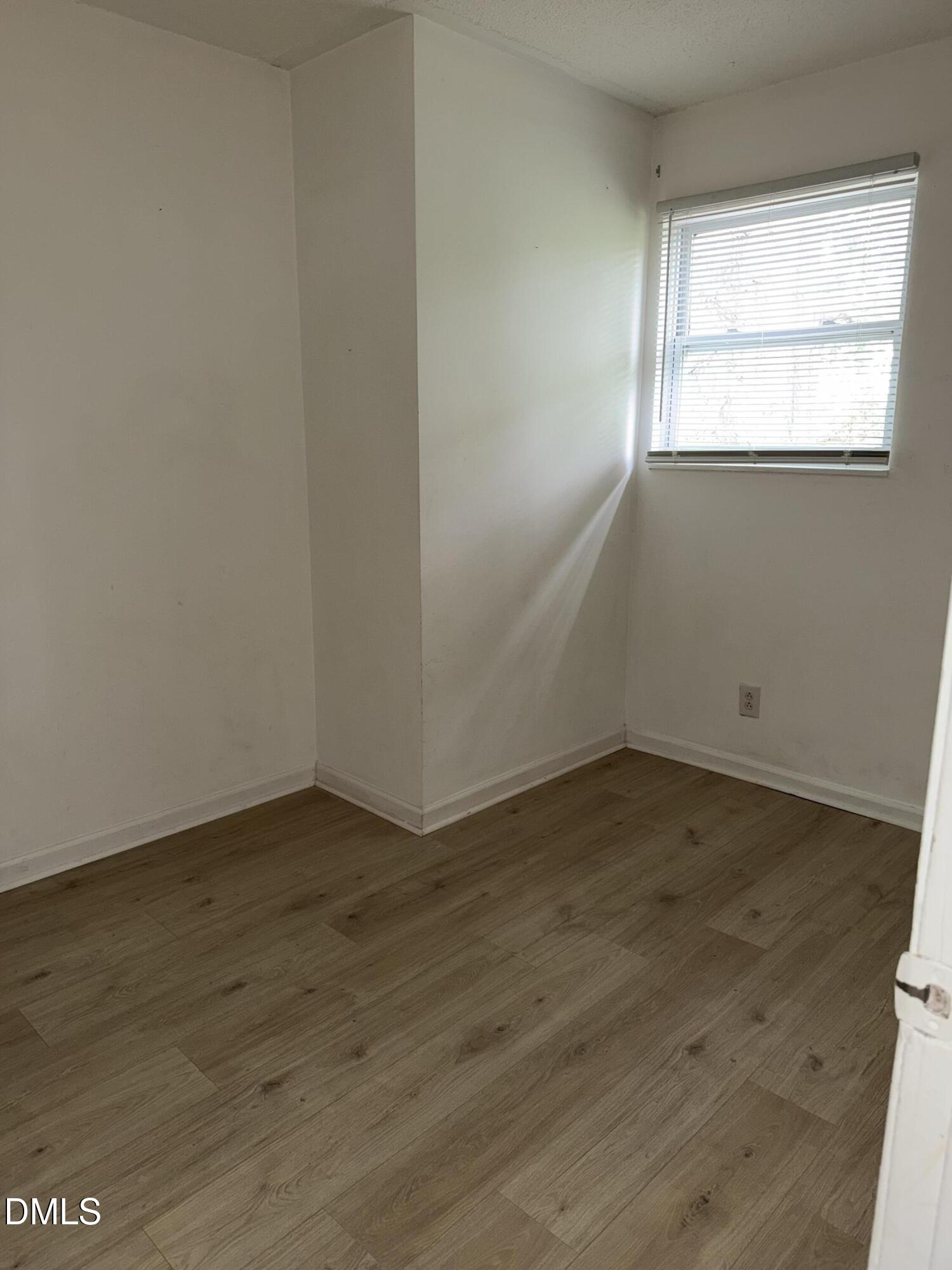 1107 Worth Street Durham, NC 27701 - Photo 9 of 17 an empty room with wooden floor and windows