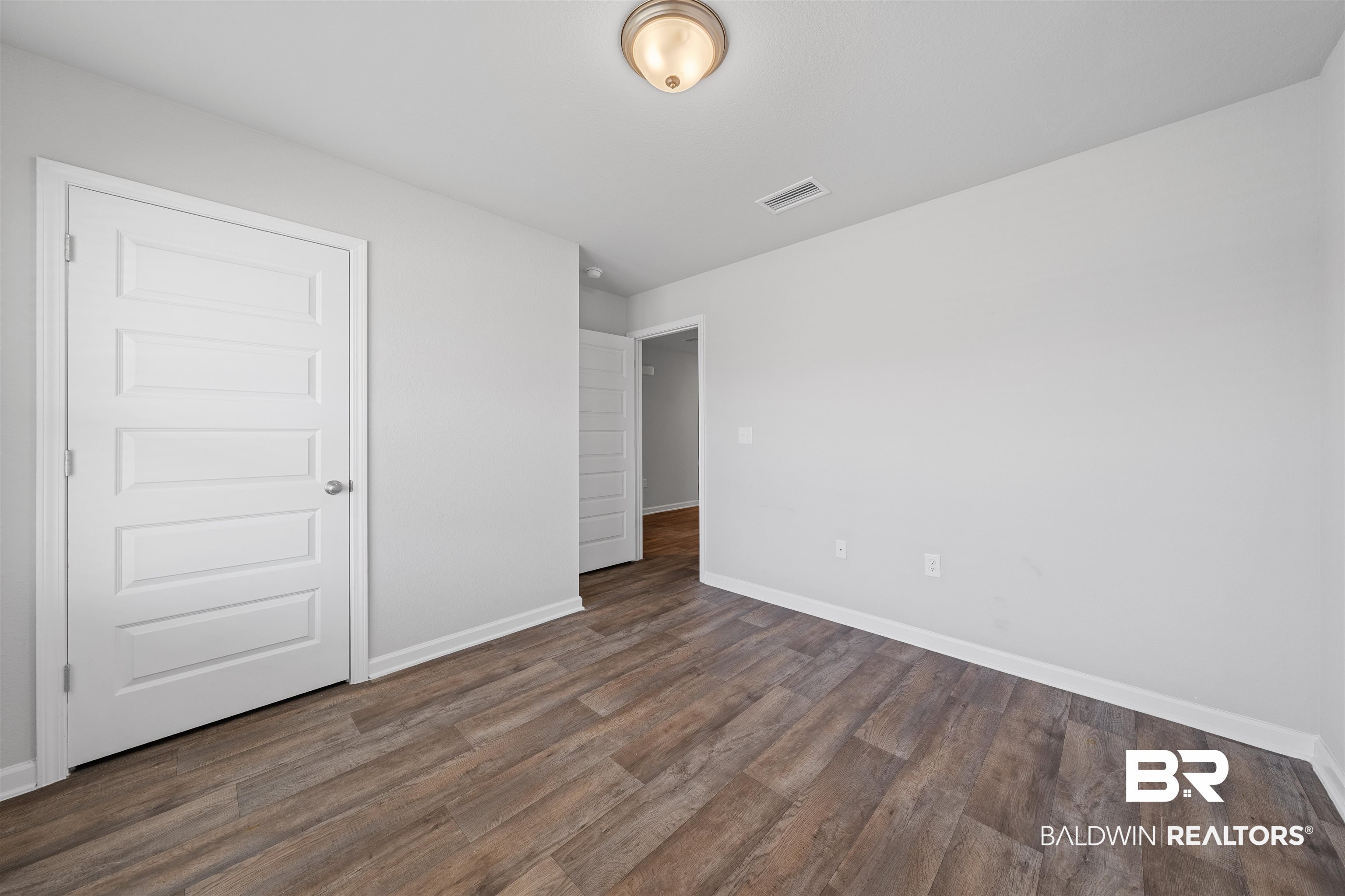 7457 Brompton Drive Foley, AL 36535 - Photo 17 of 24 Unfurnished bedroom with baseboards and dark wood-type flooring
