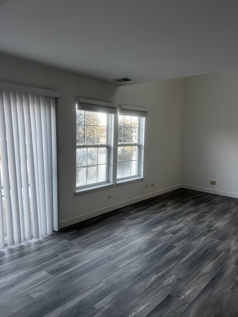 640 Beaver Court Naperville, IL 60563 - Photo 12 of 26 a view of an empty room with wooden floor and a window