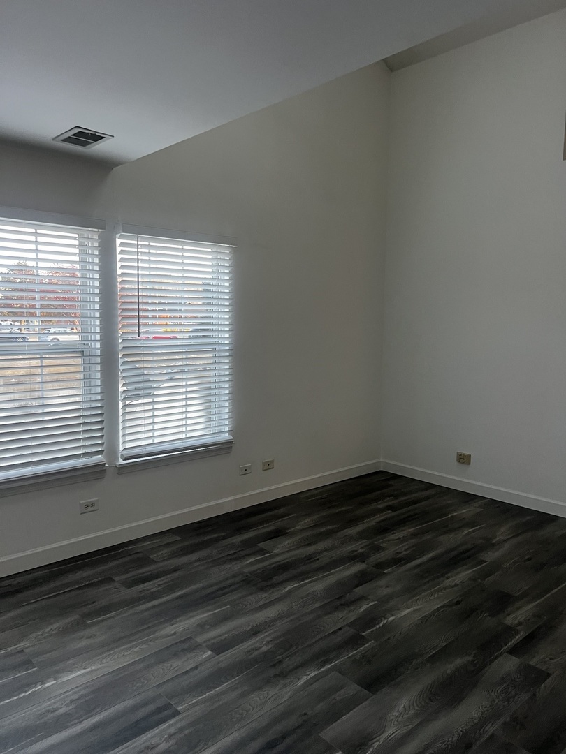 640 Beaver Court Naperville, IL 60563 - Photo 16 of 26 an empty room with wooden floor and windows
