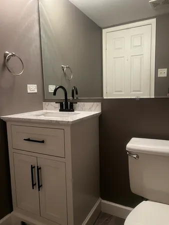 a bathroom with a toilet sink and mirror
