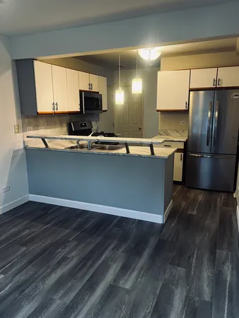a kitchen with stainless steel appliances granite countertop a stove a sink and a refrigerator